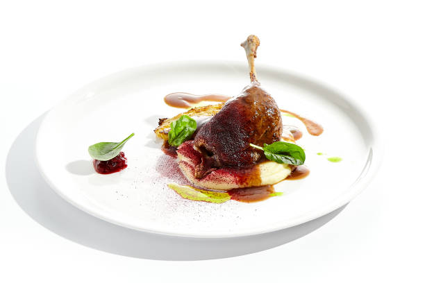 istock Delicatessen dish - duck leg confit with mashed potatoes and cabbage steak. Duck confit with vegetables and wine gravy on white plate. Gourmet meal in restaurant menu. Fusion main course. 1410762675