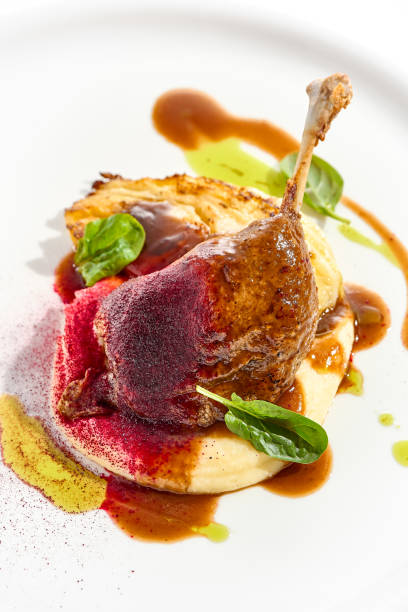 istock Delicatessen dish - duck leg confit with mashed potatoes and cabbage steak. Duck confit with vegetables and wine gravy on white plate. Gourmet meal in restaurant menu. Fusion main course. 1410762686