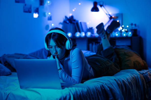 istock Girl playing on laptop in her dark room 1410763902