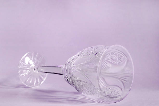Empty vintage wineglass lying on purple background