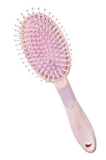 Pink plastic hair brush isolated on white background
