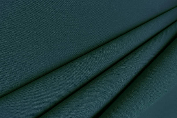 istock Green crumpled or wavy fabric texture background. Abstract linen cloth soft waves. Gabardine wool fabric. Merino yarn. Smooth elegant luxury cloth texture. Concept for banner or advertisement 1410764224