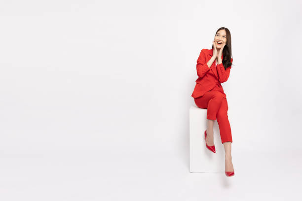 attractive beautiful asian business woman sitting on white box, excited female concept - excitement business person ecstatic passion imagens e fotografias de stock