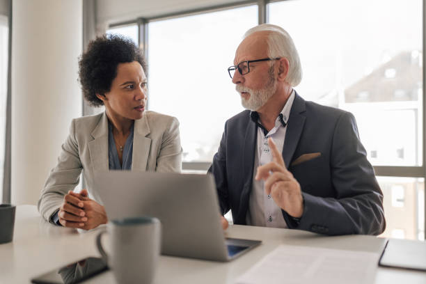 istock Professionals discussing business strategy while using laptop in office meeting. 1410766358
