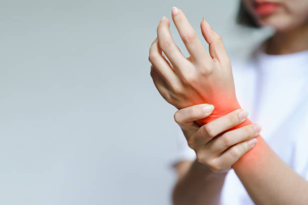 a woman has pain in her wrist. health care concept. - knuckle imagens e fotografias de stock