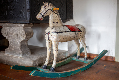 Antique wooden rocking horse in an old farmhouse. The rocking horse was photographed in a farming museum in Southern Germany. The wooden horse is over 100 years old.
