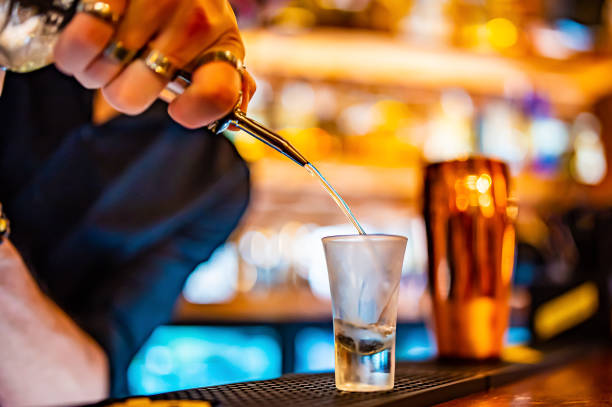istock bartender pouring distilled alcohol into a shot glass in bar 1410770105