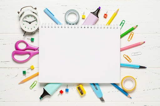 Children's accessories for study, creativity and office supplies on a white wooden background. Back to school concept. Copy space.