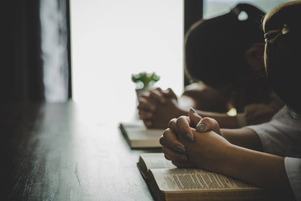 istock Two women praying worship believe 1410771665