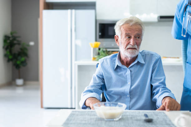 An elderly man has anorexia. Can't eat rice in the morning of the day, health concept. stock photo