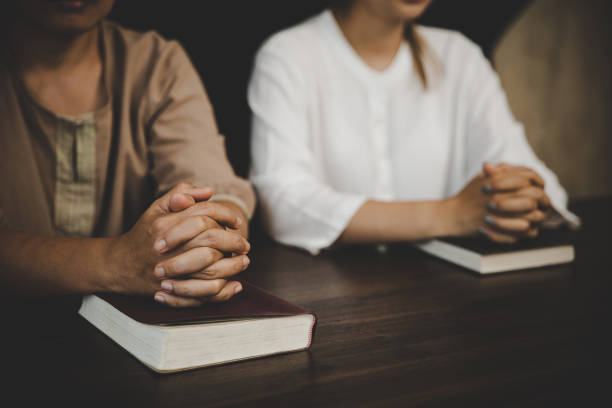 istock Two women praying worship believe 1410771940