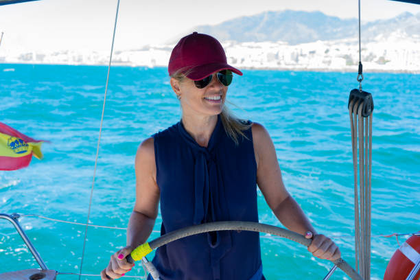 istock Long-haired blonde woman steering a sailing boat 1410774985