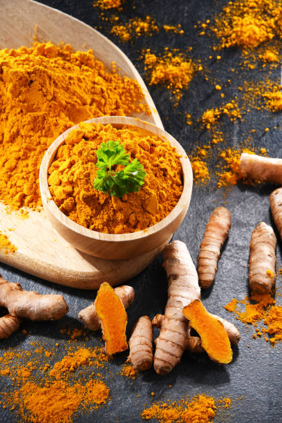 istock Composition with a bowl of ground turmeric and its fresh rhizome 1410779062