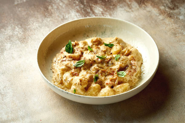 istock Gnocchi in cheese sauce with bacon on the plate. A selective trick. Close-up 1410779621