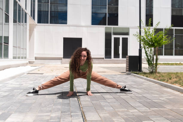 istock Young woman gymnast doing splits and smiles 1410781101