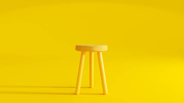 Yellow three legged chair on yellow background light from the side. Yellow three legged chair on yellow background light from the side. Minimal idea concept, 3D Render. stool stock pictures, royalty-free photos & images