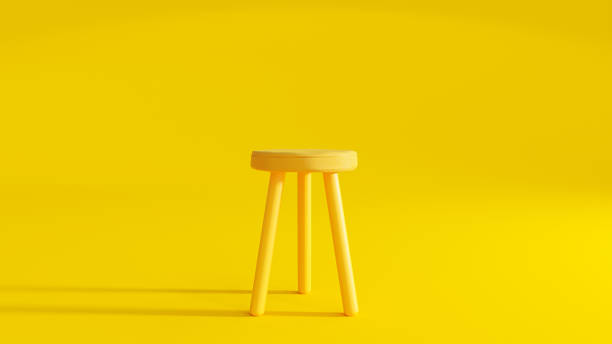 yellow three legged chair on yellow background light from the side. - stool imagens e fotografias de stock