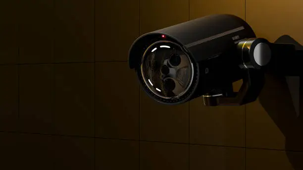 Photo of Security CCTV camera In the dark and yellow light shines on the camera.