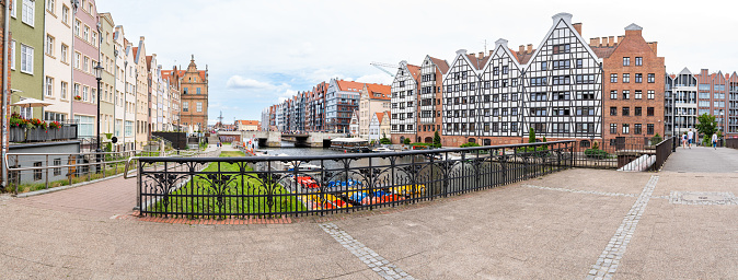The centre of Gdansk old town - old buildings standing along the Motlawa river. Blue cloudy sky on the background.