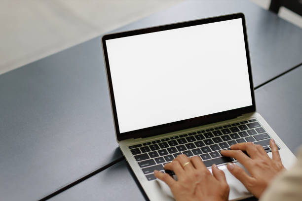 istock woman using and typing on laptop computer with blank white desktop screen on wooden table 1410783520