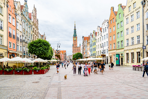 Old town of Gdansk, Srodmiescie historic district - tourists strolling along the Dluga street and chilling in cafes. Gdansk historic museum is on the background.