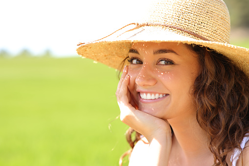 Portrait of a happy beauty woman smiling at you in a field