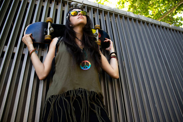 cool girl holding skateboard on her back
