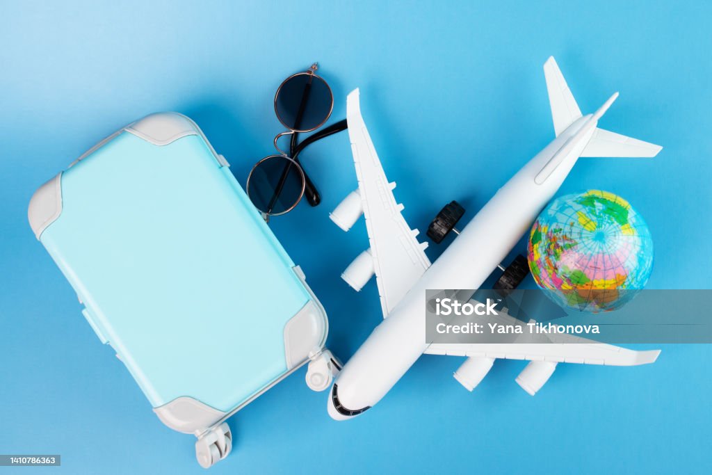 flight sale, airplane tickets, international flights, travel and trips, plane and luggage on a blue background, summer holidays and vacations Carry-On Luggage Stock Photo