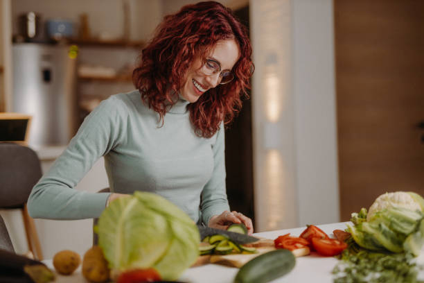 istock Young woman preparing meal at home 1410787417