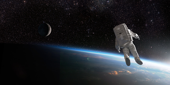 Astronauta flotando en el espacio cerca de la Tierra y la Luna photo