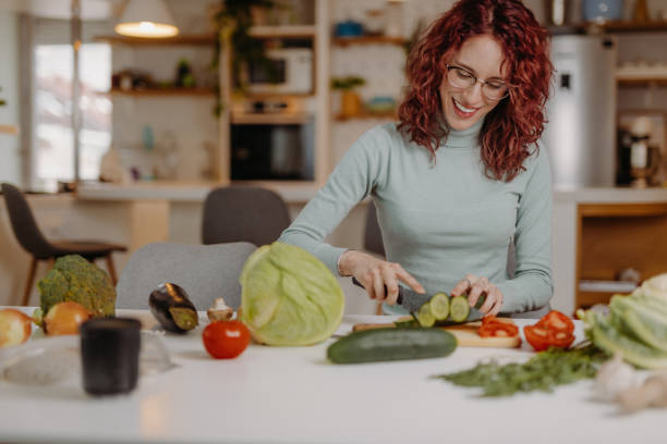 istock Young woman preparing meal at home 1410787774