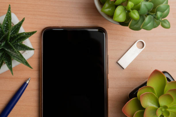 istock Blank screen smartphone on a wooden table next to a usb pen drive, flat lay 1410789263