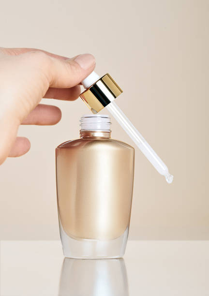 istock Woman's hand holding pipette of serum. 1410789698