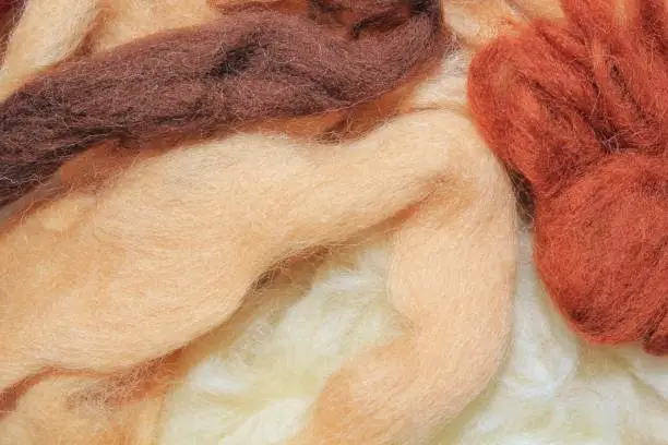 Close-up of colourful beige, brown merino wool striped background. Abstract hansmade craft knitting yarn textured pattern flatlay. Holiday autumn concept. Idea for felting, needlework, hobby. Mock up