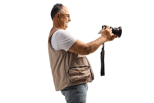 Mature man taking a photo with a professional camera isolated on white background