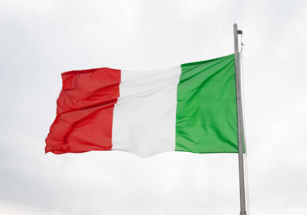 istock Italian flag flying in the wind against a cloudy sky. 1410791544