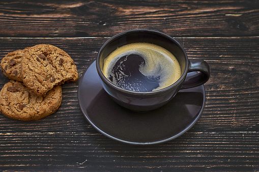 Cup of coffee and cookies on wooden rustic table