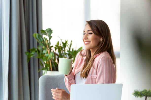 istock Young business women in the office drinking coffe and looking through a window 1410792979