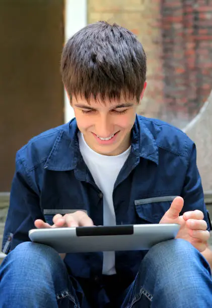 Cheerful Teenager with Tablet Computer on the Street