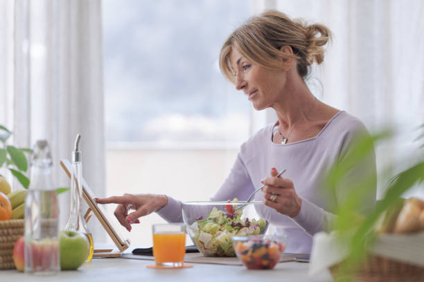 istock Woman having lunch and connecting with her tablet 1410795409