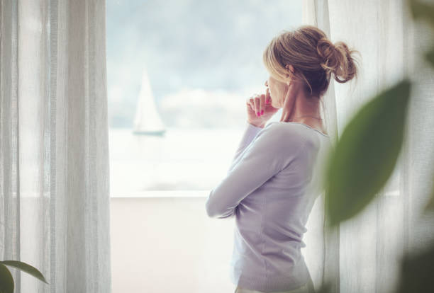 istock Mature woman standing next to a window 1410796663
