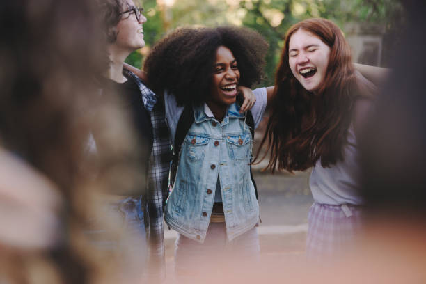 Happy teenage students standing together in a circle stock photo
