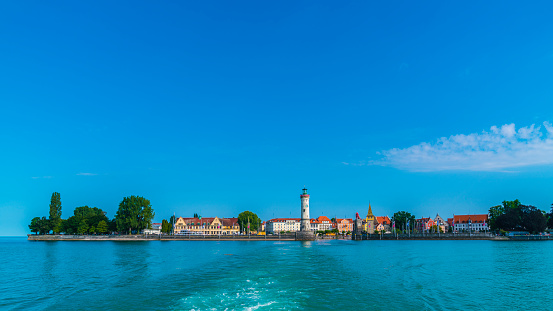 Germany, Lindau island city port lighthouse and lion, beautiful waterfront panorama view to old town houses and skyline