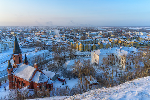 A panoramic view of the winter city of Tobolsk (Russia) from a bird's eye view on a sunny cold morning. Due to severe frost, the city is in a light fog, smoke rises from the city pipes
