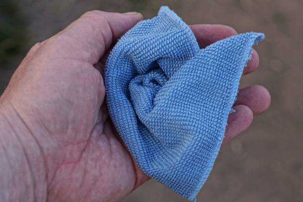 istock a hand holds one crumpled blue fabric handkerchief 1410800734