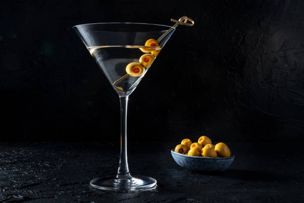 istock Martini, a glass with spicy olives on a toothpick, on a black background 1410802018