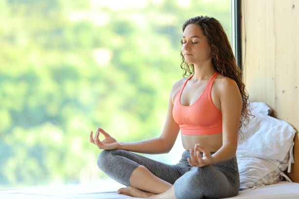 istock Woman doing yoga exercise in a room window 1410803109