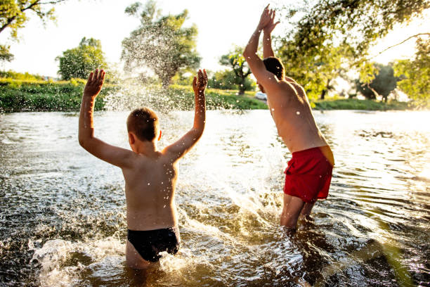 istock Father and son having fun at river on sunny summer day 1410804513