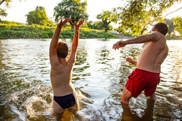 istock Father and son having fun at river on sunny summer day 1410804524