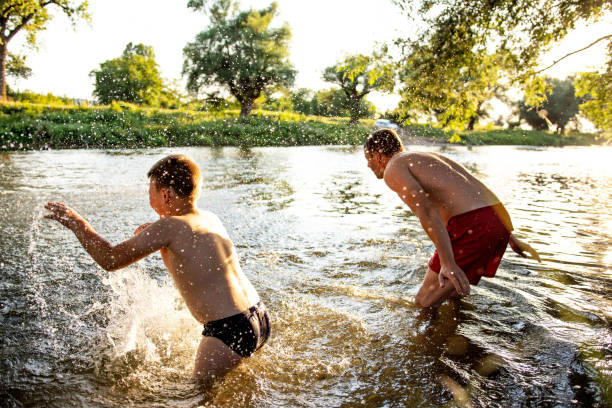 istock Father and son having fun at river on sunny summer day 1410804539